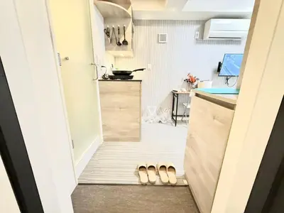 a small kitchen with two pairs of slippers on the floor at Shinjuku downtown b3 in Tokyo