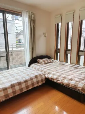 two beds in a room with windows at Aki House\u5c45\u4f4f\u578b\u6c11\u6cca\u5c0f\u5ca9\u99c5\u307e\u3067\u9001\u8fce\u3042\u308a in Tokyo