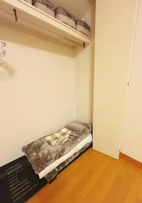 a small room with a bed on a shelf at Aki House\u5c45\u4f4f\u578b\u6c11\u6cca\u5c0f\u5ca9\u99c5\u307e\u3067\u9001\u8fce\u3042\u308a in Tokyo