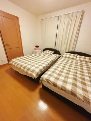 two beds sitting next to each other in a room at Aki House\u5c45\u4f4f\u578b\u6c11\u6cca\u5c0f\u5ca9\u99c5\u307e\u3067\u9001\u8fce\u3042\u308a in Tokyo