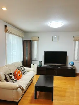 a living room with a couch and a flat screen tv at Aki House\u5c45\u4f4f\u578b\u6c11\u6cca\u5c0f\u5ca9\u99c5\u307e\u3067\u9001\u8fce\u3042\u308a in Tokyo