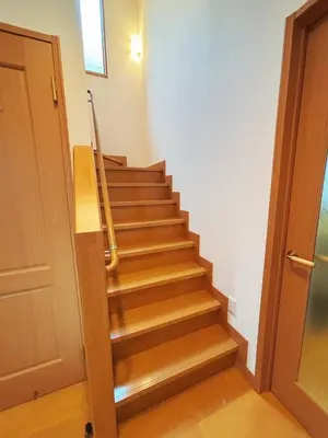 a staircase with wooden steps next to a door at Aki House\u5c45\u4f4f\u578b\u6c11\u6cca\u5c0f\u5ca9\u99c5\u307e\u3067\u9001\u8fce\u3042\u308a in Tokyo