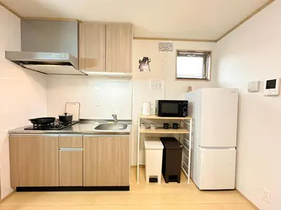 a small kitchen with a refrigerator and a sink at Spacious 2BR TownHouse, Central Shinjuku City in Tokyo