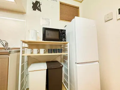 a kitchen with a white refrigerator and a microwave at Spacious 2BR TownHouse, Central Shinjuku City in Tokyo