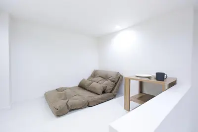 a dog bed and a table in a white room at Monthly Studio G2 in Tokyo