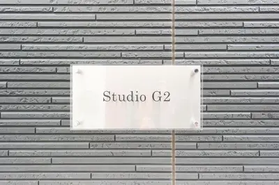 a sign on the side of a brick wall at Monthly Studio G2 in Tokyo
