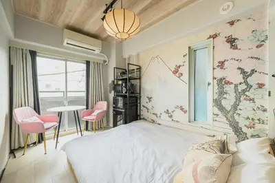 a bedroom with a white bed and pink chairs at Sakura RYOKAN MEJIRO2 in Tokyo
