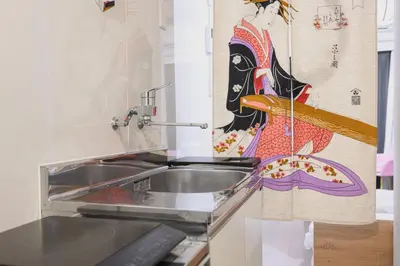 a kitchen with a sink and a painting on the wall at Sakura RYOKAN MEJIRO2 in Tokyo