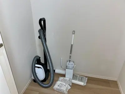 a black hose hanging on a wall next to a toilet at monthly EveryNet SHINJUKU in Tokyo