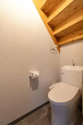 a white toilet in a bathroom with a wooden ceiling at \u30a2\u30f3\u30c9\u30b9\u30c6\u30a4\u5f25\u751f\u753a4\u4e01\u76ee101 in Tokyo