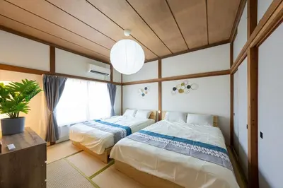 a bedroom with two beds and a large window at \u30a2\u30f3\u30c9\u30b9\u30c6\u30a4\u5341\u6761\u4ef2\u539f1\u4e01\u76ee in Tokyo