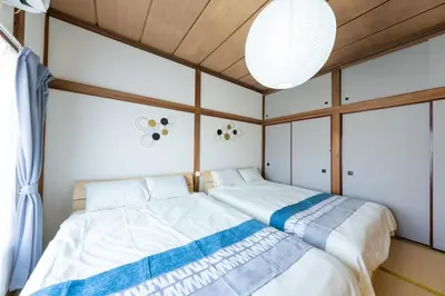 a bedroom with two beds and a chandelier at \u30a2\u30f3\u30c9\u30b9\u30c6\u30a4\u5341\u6761\u4ef2\u539f1\u4e01\u76ee in Tokyo