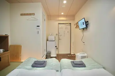 a hospital room with two beds and a refrigerator at Shin-Okachimachi I Metro 6 minutes I Direct To Airport in Tokyo