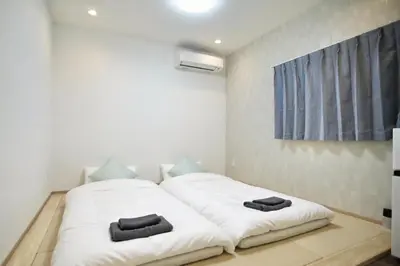 a bedroom with a white bed with two black towels on it at Shin-Okachimachi I Metro 6 minutes I Direct To Airport in Tokyo