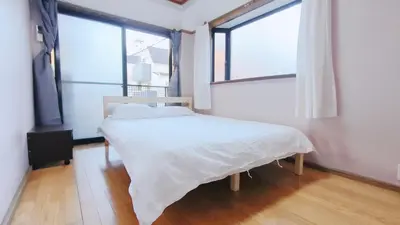 a bed in a room with a large window at Shinjuku 2bed rooms sunny apart ment#2\u5ba41\u5385\u9633\u5149\u516c\u5bd3#\u9ad8\u901f\u65e0\u9650\u5236\u7f51\u8def2#1 in Tokyo