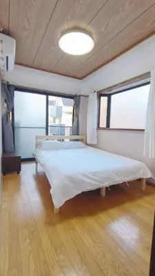 a large bed in a room with a large window at Shinjuku 2bed rooms sunny apart ment#2\u5ba41\u5385\u9633\u5149\u516c\u5bd3#\u9ad8\u901f\u65e0\u9650\u5236\u7f51\u8def2#1 in Tokyo