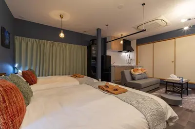 a large white bed in a room with a living room at \u30a2\u30f3\u30c9\u30b9\u30c6\u30a4\u5f25\u751f\u753a4\u4e01\u76ee201 in Tokyo