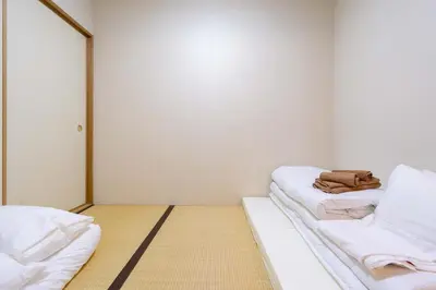 a room with two beds and a purse sitting on them at \u30a2\u30f3\u30c9\u30b9\u30c6\u30a4\u5f25\u751f\u753a4\u4e01\u76ee201 in Tokyo