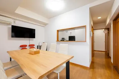 a dining room with a table and a flat screen tv at -Belmazon meguro402- 7 minutes to Shibuya Station in Tokyo