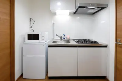 a white kitchen with a sink and a microwave at LIFE TOWN Nishiarai II in Tokyo