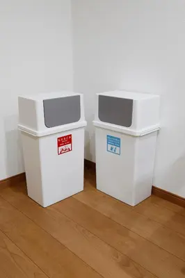 two white trash cans sitting next to a wall at LIFE TOWN Nishiarai II in Tokyo