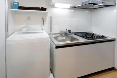 a white kitchen with a sink and a stove at LIFE TOWN Nishiarai II in Tokyo