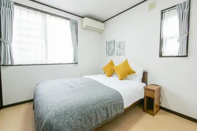 a white bedroom with a bed and two windows at \u5927\u5cf6Villa in Tokyo
