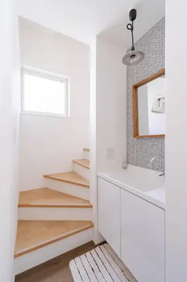 a white bathroom with stairs and a mirror at Shibuya Base in Tokyo