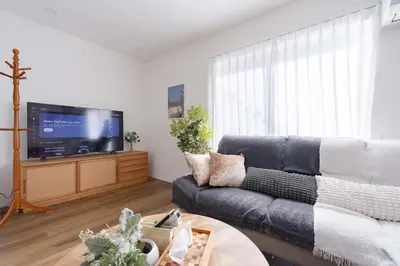 a living room with a couch and a flat screen tv at Shibuya Base in Tokyo