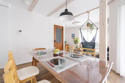 a kitchen and dining room with a wooden table and chairs at Shibuya Base in Tokyo