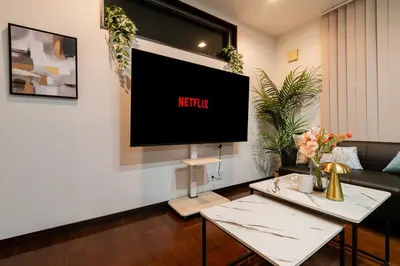 a living room with a flat screen tv on a wall at GC TOKYO Shinjuku-Ochiai in Tokyo