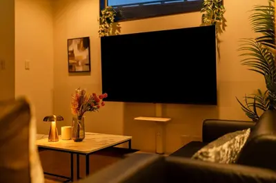 a living room with a tv and a table with flowers at GC TOKYO Shinjuku-Ochiai in Tokyo