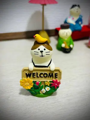 a small figurine of a cat in a welcome sign at memento 20minutes from Haneda Airport 10minute walk from JR Kamata Station in Tokyo
