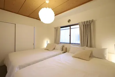 two beds in a room with two windows at memento 20minutes from Haneda Airport 10minute walk from JR Kamata Station in Tokyo