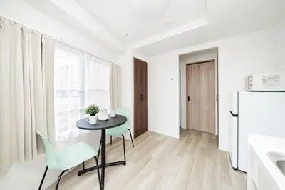 a kitchen and dining room with a table and a refrigerator at Sunlit Canopy - A Cozy Stay in Tokyo Shinjuku Area, with Easy City Access to Shibuya in Tokyo