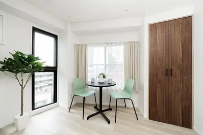 a dining room with a table and green chairs at Sunlit Canopy - A Cozy Stay in Tokyo Shinjuku Area, with Easy City Access to Shibuya in Tokyo