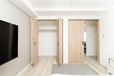 a room with two sliding doors and a television at Sunlit Canopy - A Cozy Stay in Tokyo Shinjuku Area, with Easy City Access to Shibuya in Tokyo
