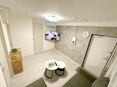 a small room with a table and a tv on the wall at \u6696\u71c8 DANTO inn 3F in Tokyo