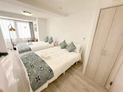 a bedroom with two beds and a large window at \u6696\u71c8 DANTO inn 3F in Tokyo