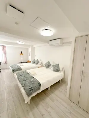 a white bedroom with two beds in it at \u6696\u71c8 DANTO inn 3F in Tokyo