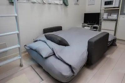 a bedroom with a bed with pillows on it at Cruise Inn Kitasenju Station Front2 in Tokyo