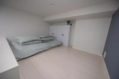 a white room with a bed and a closet at Cruise Inn Kitasenju Station Front2 in Tokyo