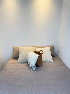 a bed with pillows and a basket on it at PUZZLE hotel 301 in Tokyo