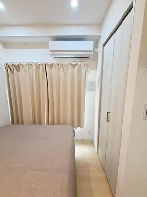 a bedroom with a bed and a curtain and a closet at PUZZLE hotel 301 in Tokyo