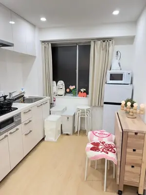 a kitchen with white appliances and a table and chairs at PUZZLE hotel 301 in Tokyo