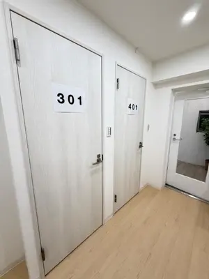 an empty room with two doors with numbers on them at PUZZLE hotel 301 in Tokyo
