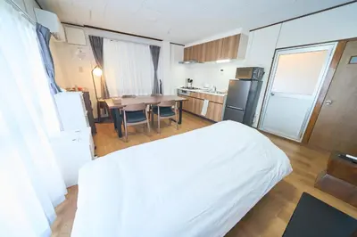 a room with a bed and a kitchen with a table at Kita-Senju House in Tokyo