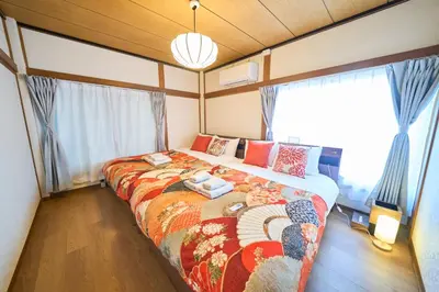 a bedroom with a large bed in front of windows at Kita-Senju House in Tokyo