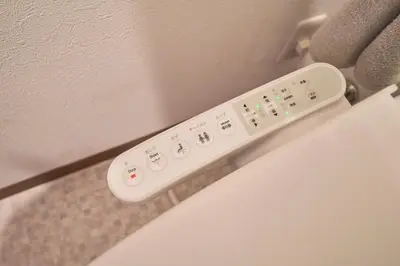 a white remote control sitting on the side of a wall at Kita-Senju House in Tokyo