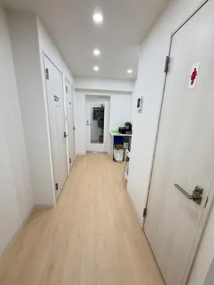 an empty hallway with white walls and wooden floors at PUZZLE hotel 401 in Tokyo